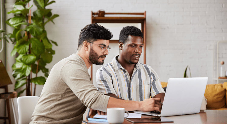  An image of two people working together on a laptop. They appear to be in a professional setting, possibly discussing or analyzing something on the screen. 