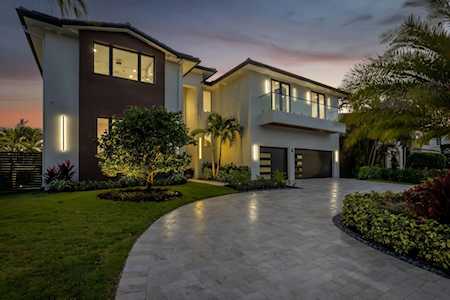 Modern two-story home at dusk with a curved driveway, two-car garage, and landscaped yard.
