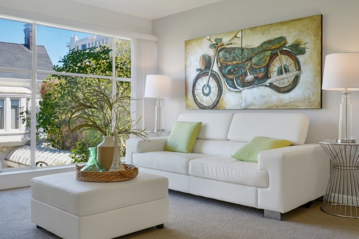 Modern living room with couch and large window view, symbolizing the decision to buy a home with or without a real estate agent