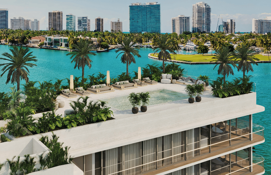 Waterfront condominium rooftop pool terrace overlooking a turquoise bay and high-rise skyline.