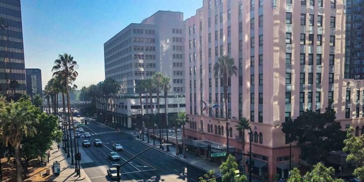 Downtown San Jose street lined with office buildings and palm trees.