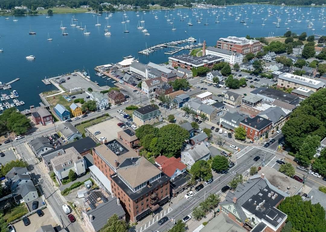 Coastal town and harbor viewed from above, with sailboats moored offshore.
