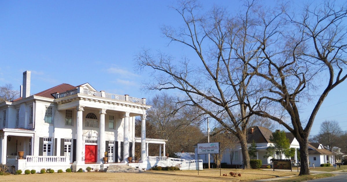 Historic white columned home on a tree-lined street in the Geneva Street Historic District, Opelika, Alabama