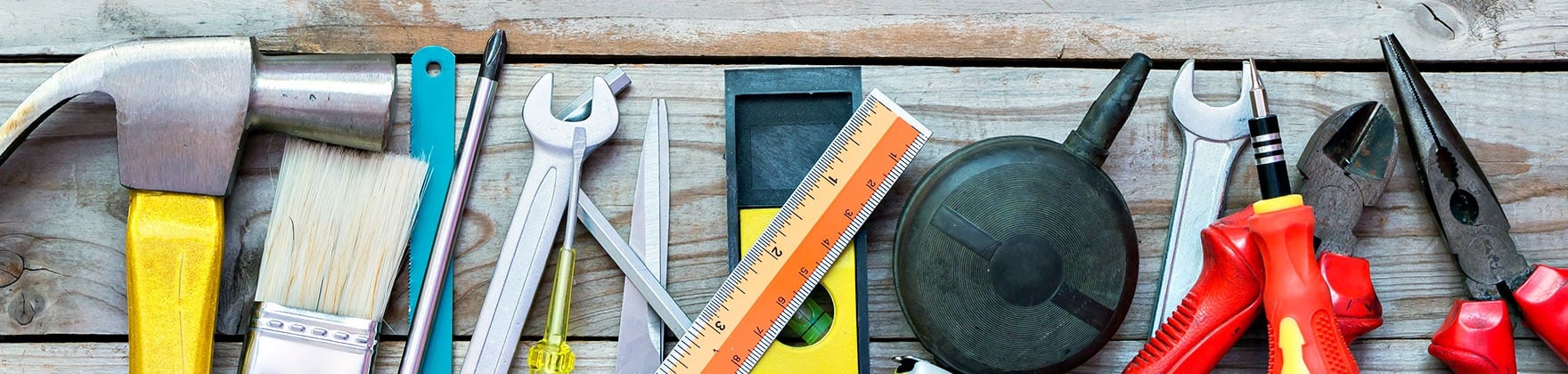 Home repair tools arranged across weathered wooden boards.