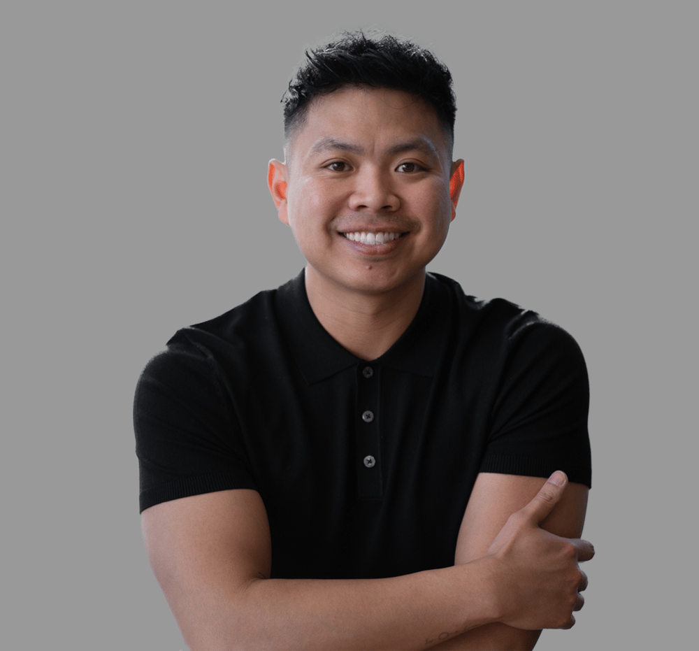 Smiling man in a black polo shirt with his arms crossed