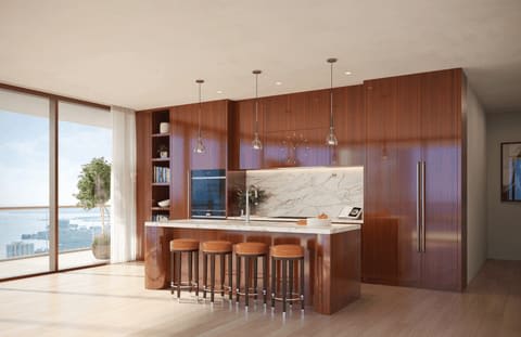 Modern kitchen with walnut cabinetry, a marble island, and large windows overlooking the water.