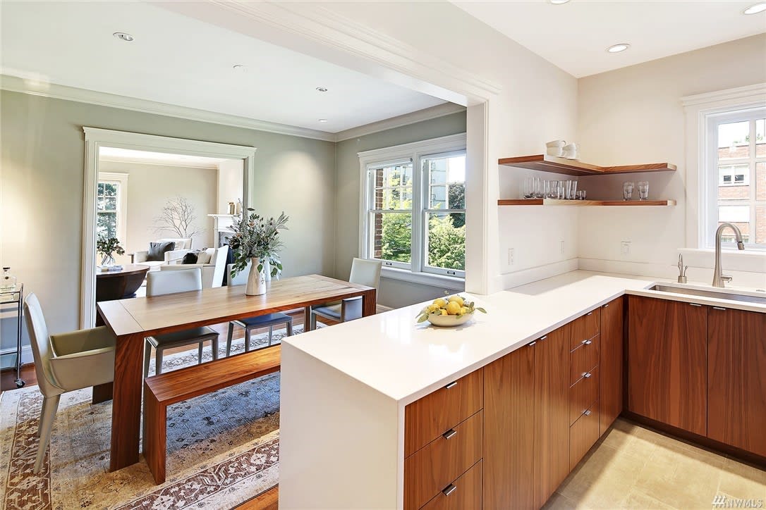 An open-plan luxury kitchen with wooden accents flows into the dining area, offering a spacious, elegant home feel.