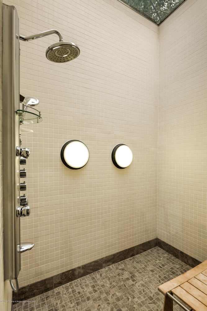 Walk-in shower with a rainfall showerhead, multiple body jets, and a skylight.