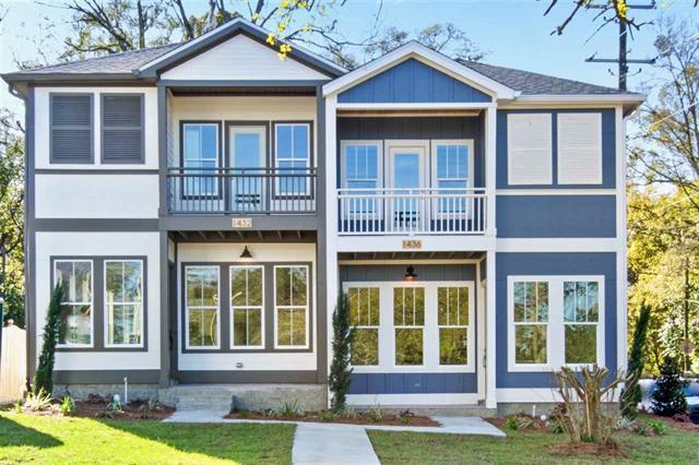  two-story house with a modern design, featuring large windows and a balcony on the upper floor. The exterior is a combination of light and dark colors, giving it a contemporary look. 