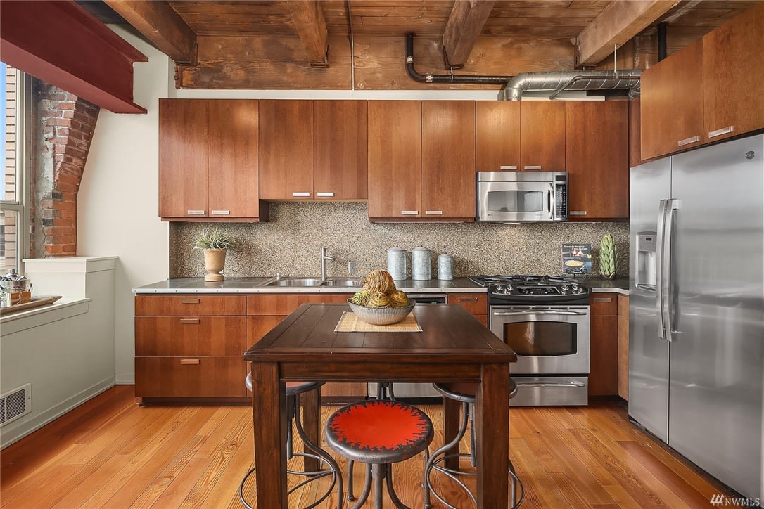 A luxurious kitchen with wooden floors and stainless steel appliances.