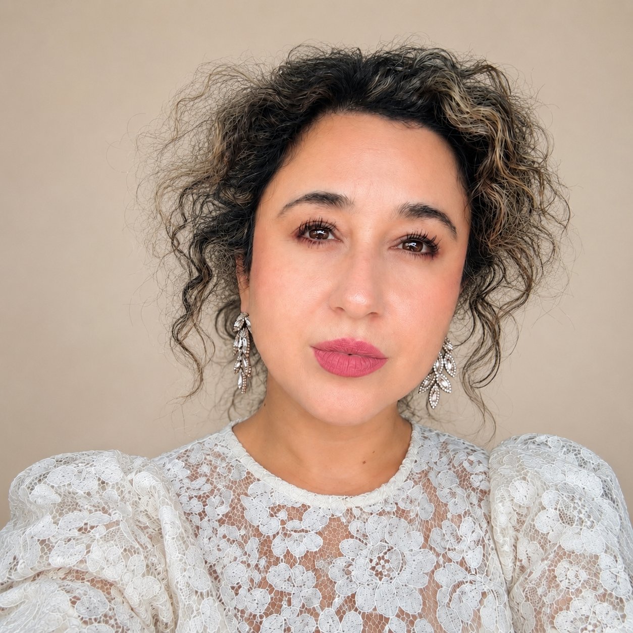 Johanna Gutierrez wearing a white lace blouse and dangling earrings