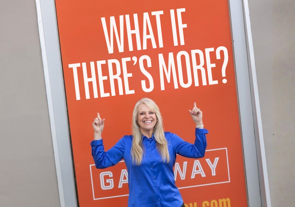 Sharla Ellis pointing to a sign that says “What If There’s More?” for a blog about increasing your ability to earn and creating more possibilities.