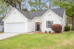 White single-story house with an attached garage, gray roof, and landscaped front lawn.