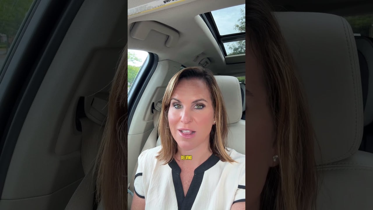 Melissa Infanzon speaking to camera from a car’s front seat, wearing a white blouse with black trim.
