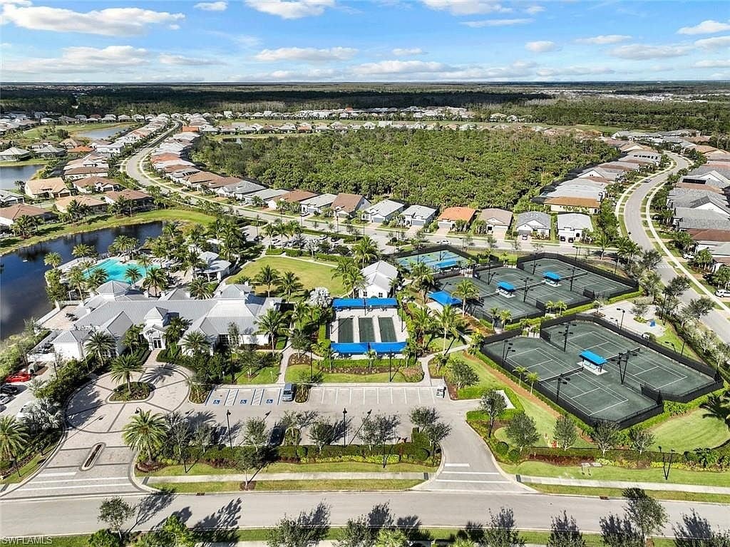 Aerial of Greyhawk at Golf Club of the Everglades showing tennis courts, pool, clubhouse, and surrounding homes in Naples FL