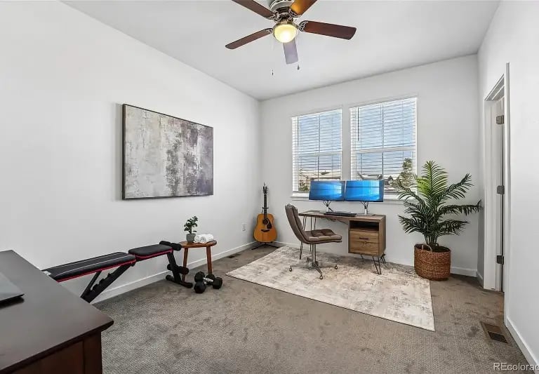 Secondary bedroom set up as a home office and workout space