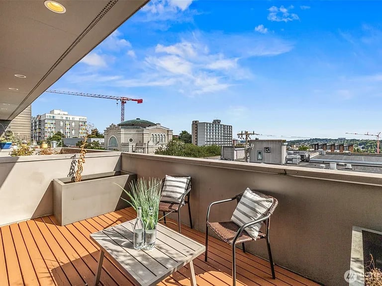 Rooftop terrace with wood decking and seating overlooking the Seattle skyline.