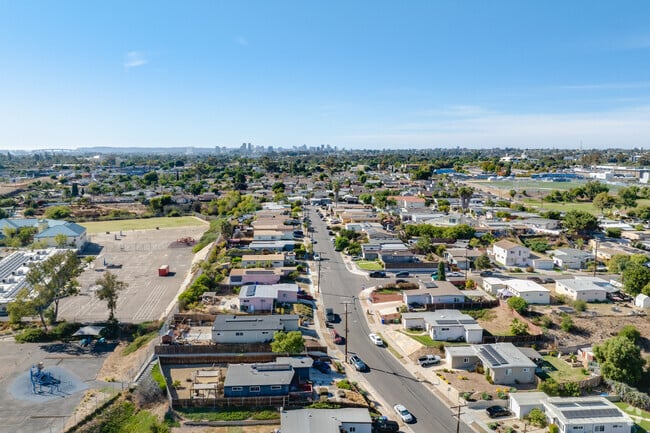 Aerial view of Chollas View neighborhood in Southeast San Diego with single-family homes, city skyline in the distance, and schoolyards—showcasing affordable real estate near downtown.