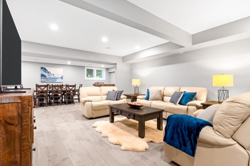 Open-plan living room with cream sofas, a dark wood coffee table, and a dining area.