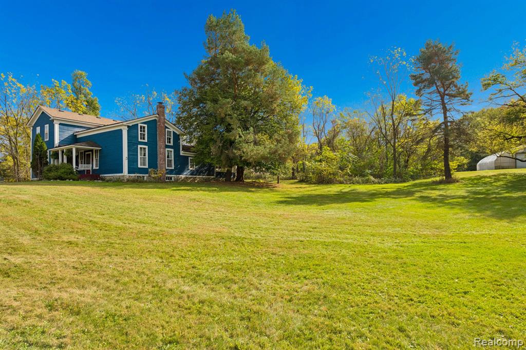 Backyard of the 4-bedroom home for sale at 13278 9 Mile Road, South Lyon, MI,
