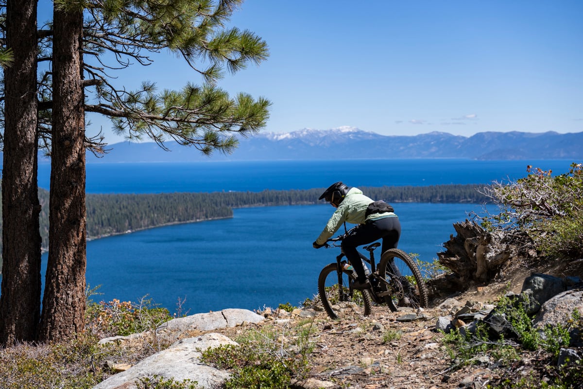 Mountain biker above lake with blue Tahoe visible below