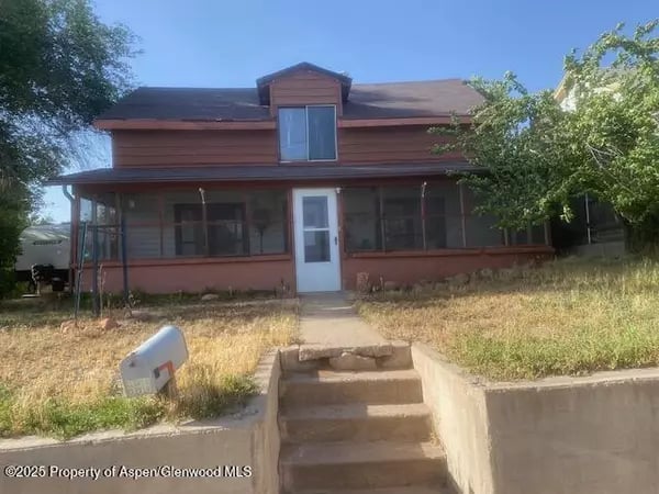 Two-story red-brown house with a screened porch, central entry, and concrete steps.