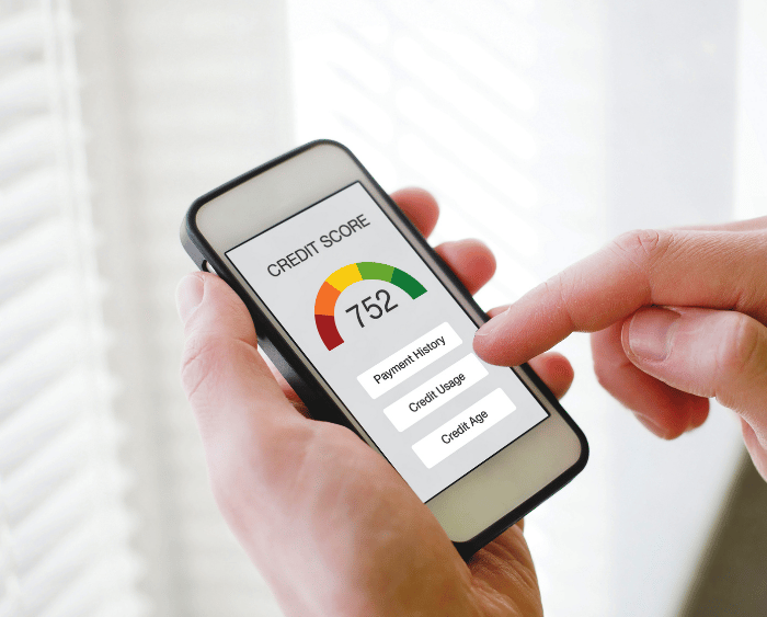 Hands checking a credit score of 752 on a smartphone.