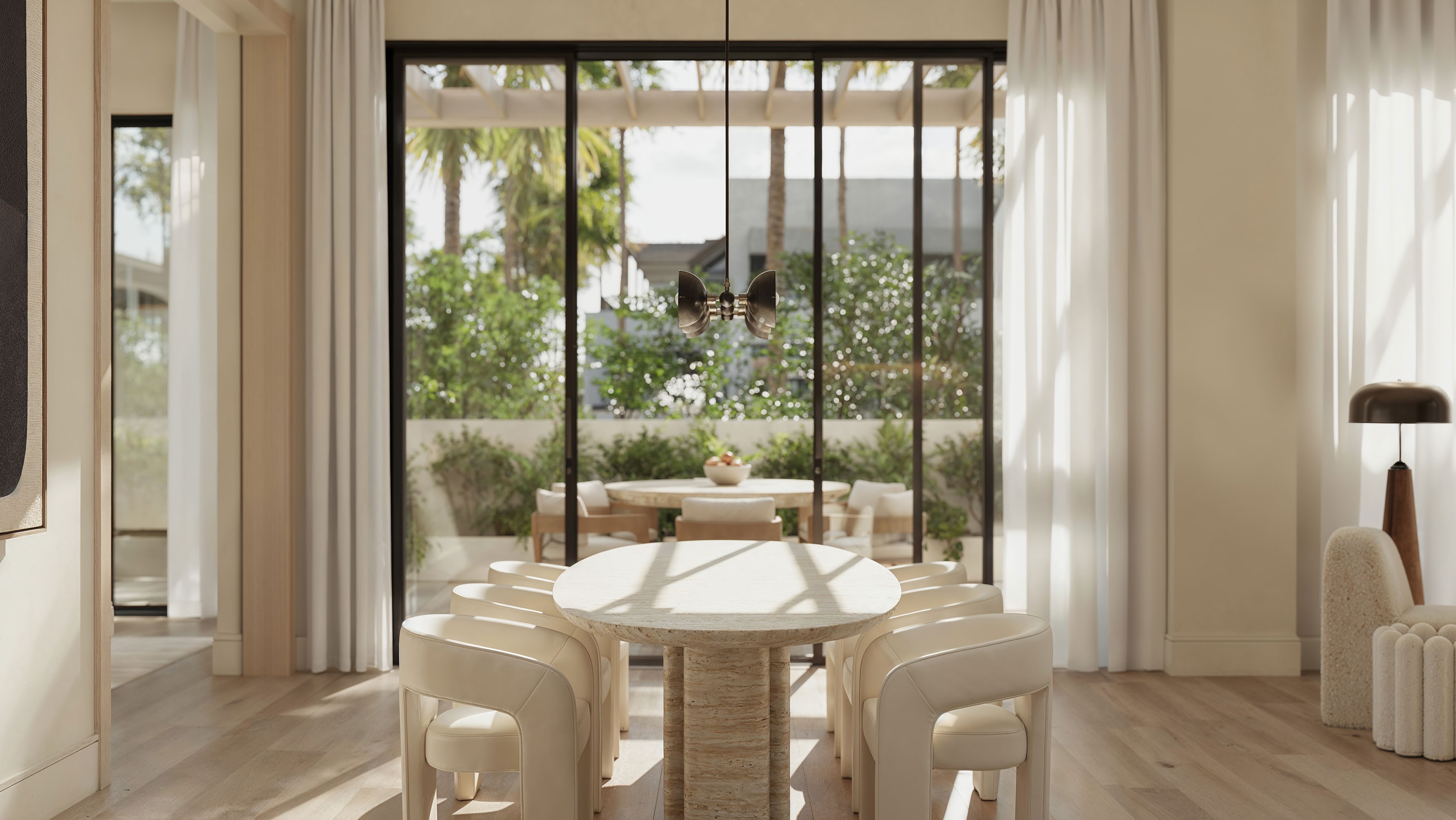 Rendering of a dining room with a round stone table and glass doors opening to a terrace at The Avenue Naples