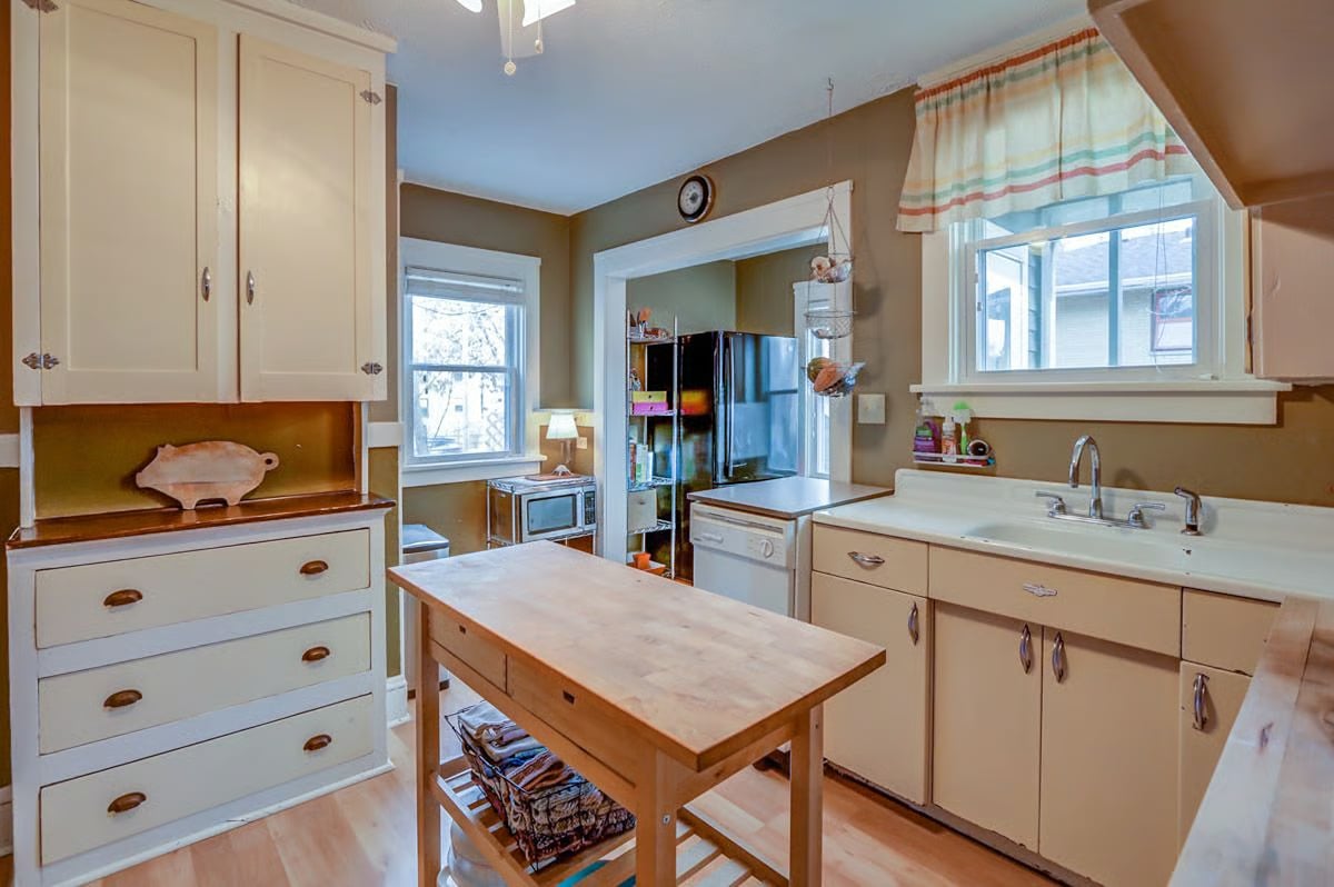 Kitchen with cream cabinets, a butcher-block worktable, and a double-basin sink.