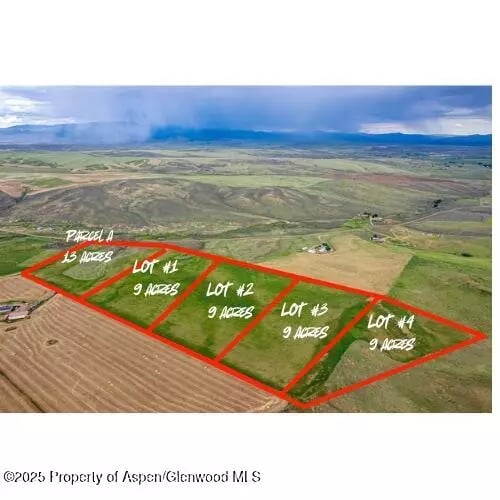 Aerial view of five marked acreage parcels across open land, with distant mountains.