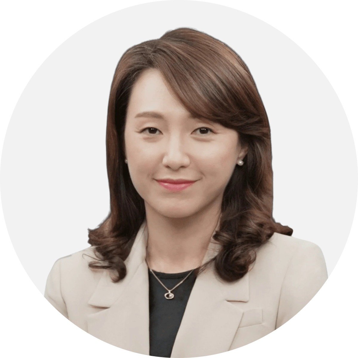 Eun Kyu Lee in a beige blazer and pendant necklace.