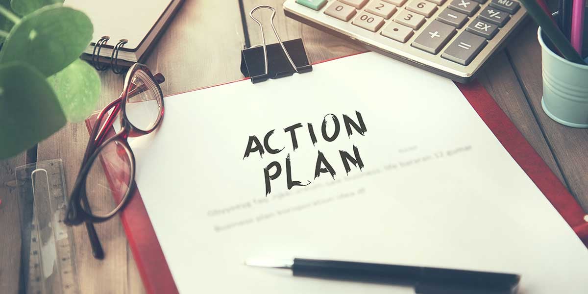 Action plan on a desk beside eyeglasses, a calculator, and a pen.