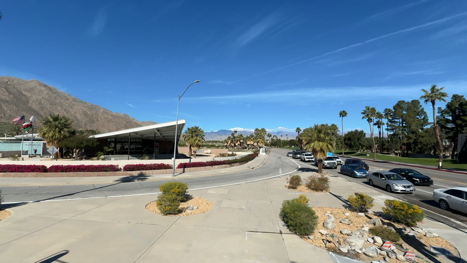 Cars on a Palm Springs roadway with desert mountains in the background