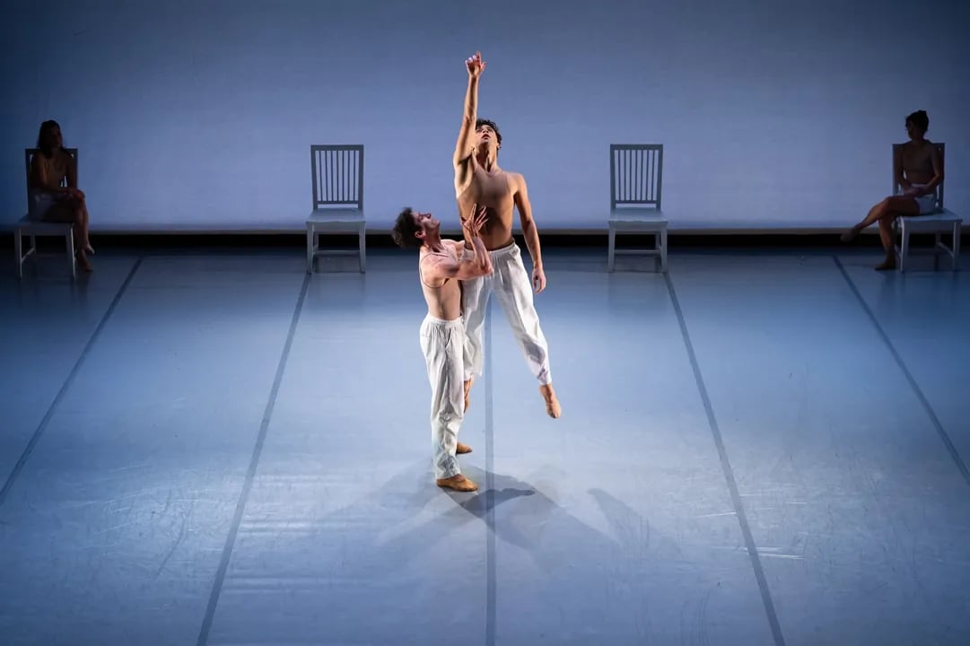 Dancers from Smuin Contemporary Ballet perform a dramatic central lift during a contemporary dance piece on a stage in San Francisco.