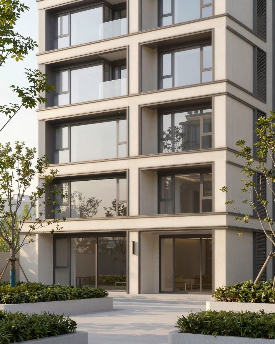 Modern apartment building with recessed balconies and landscaped planters at its entrance.