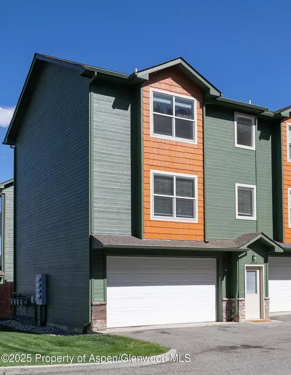 Attached townhome with green and orange siding and a white garage.