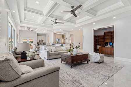 Bright living room with coffered ceiling, sectional seating, and open kitchen.
