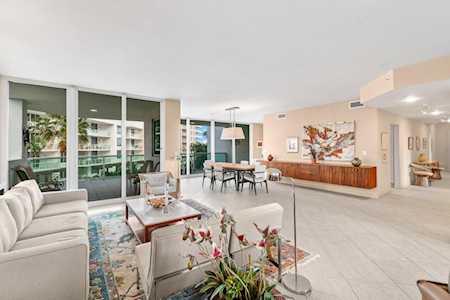 Open-plan living and dining room with floor-to-ceiling glass doors and contemporary artwork.