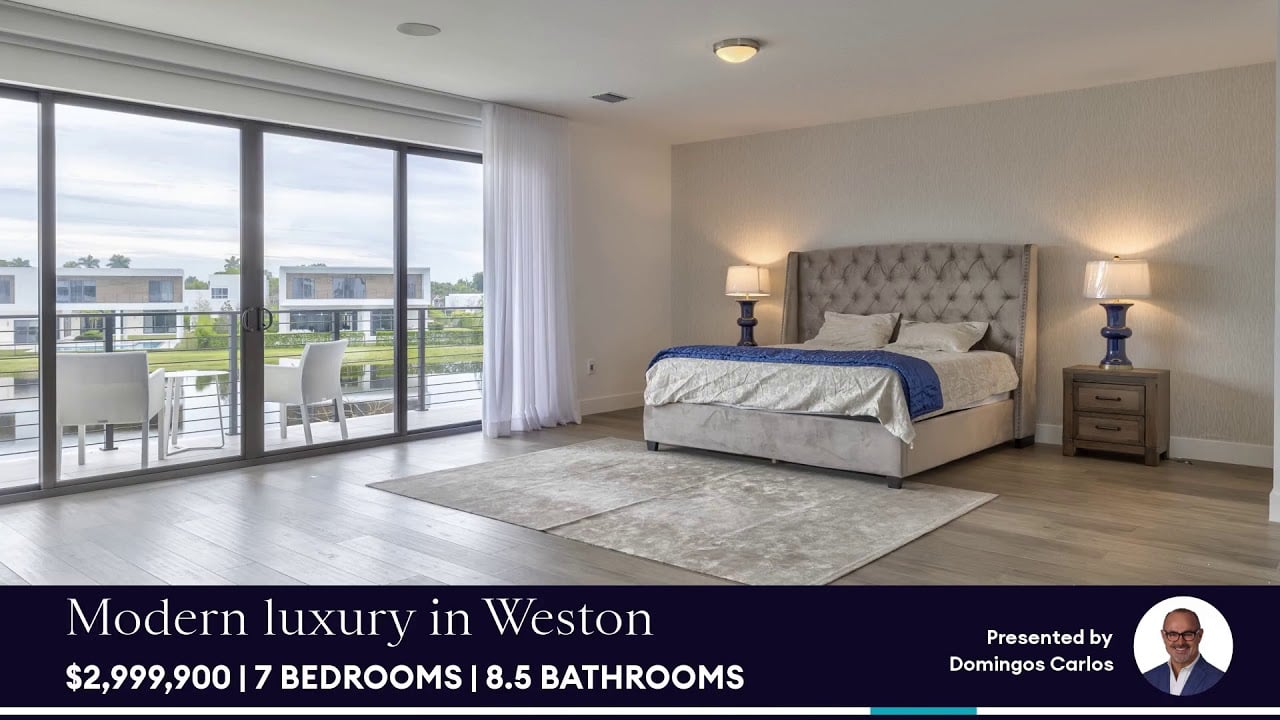 Furnished bedroom with a tufted bed and sliding glass doors opening to a balcony.