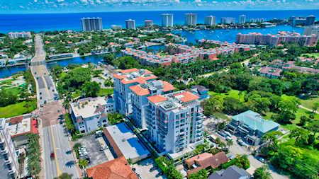 Aerial view of East Boca homes and condominiums near blue water and a distant skyline.