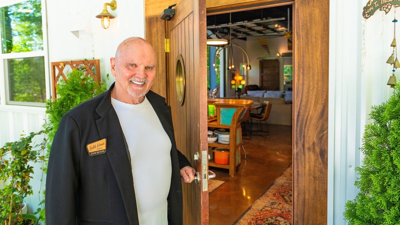 Bald Head Realty agent John Becker standing at an open wooden doorway.
