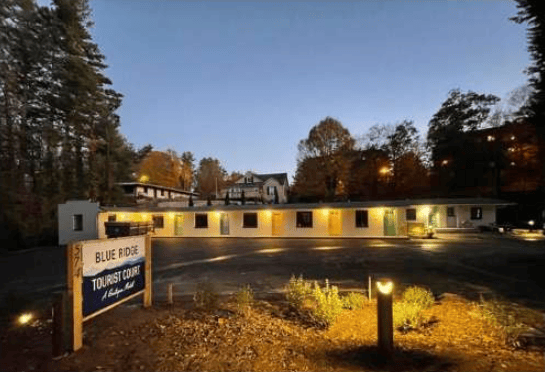 Blue Ridge Tourist Court at dusk, with illuminated rooms and a roadside sign.