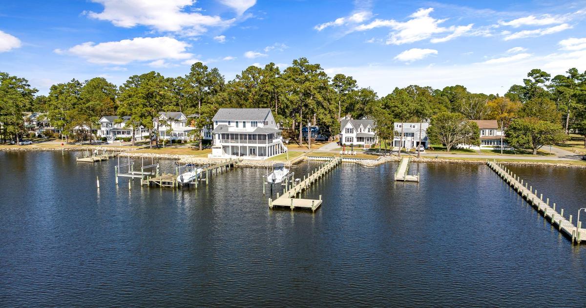 Waterfront homes and private docks line a tree-covered shore.