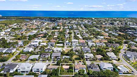 Aerial view of East Boca homes and tree-lined streets, with the Atlantic Ocean beyond.