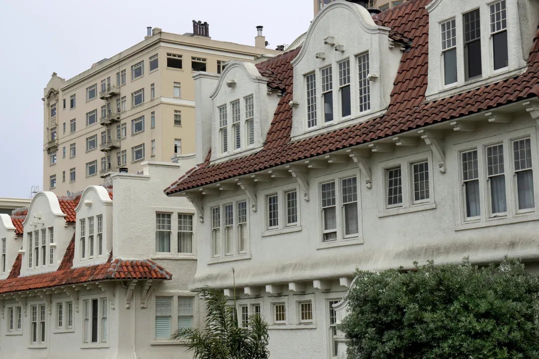 A row of elegant, white, historic buildings with red-tiled roofs in Pacific Heights, San Francisco.