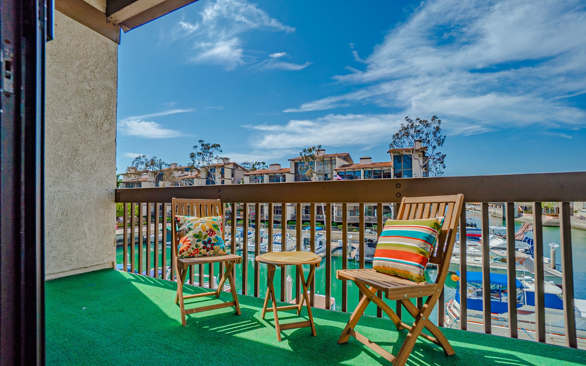Balcony with seating overlooking a marina filled with boats.