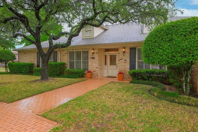 Brick home with a mature shade tree and brick walkway leading to the front entrance.