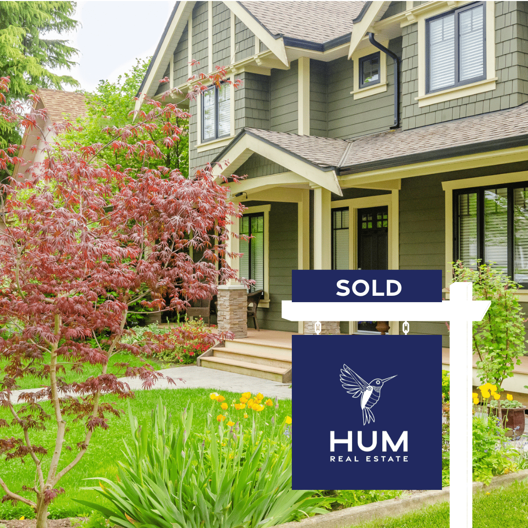 home with hum real estate sold sign in yard