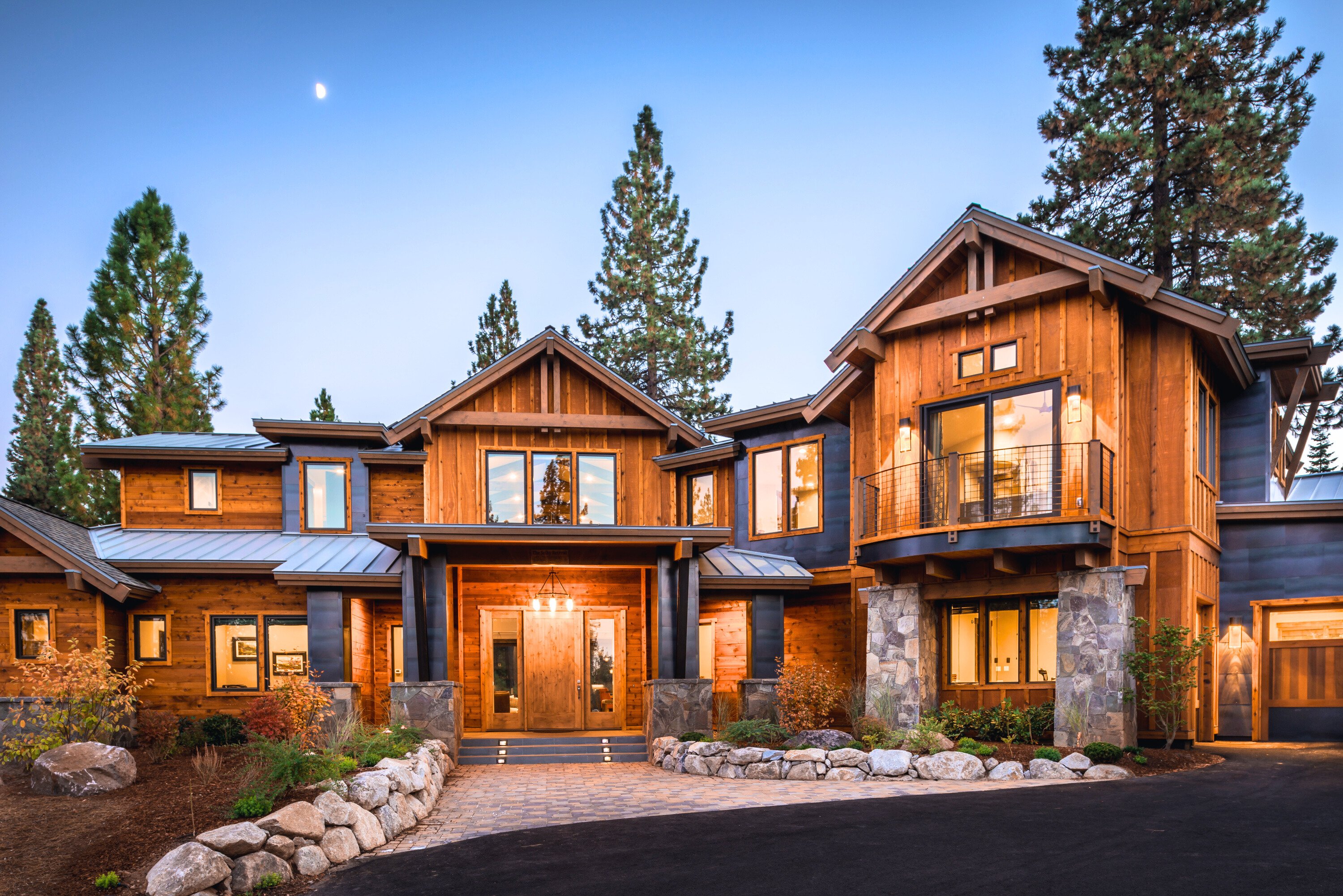 Tahoe-style home with wood siding, a second-story balcony, and a landscaped stone entry.