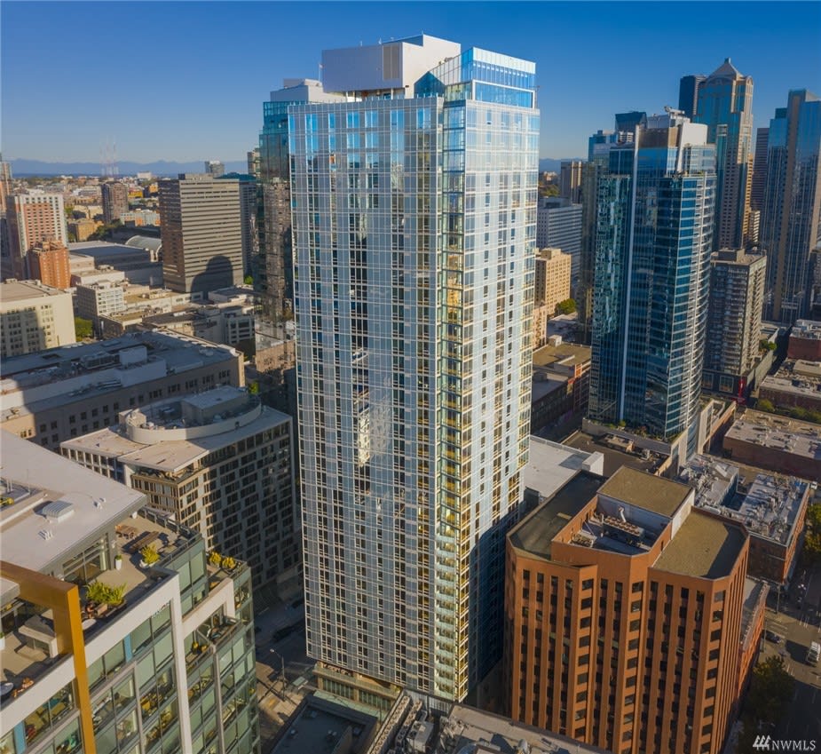 A bustling cityscape with a towering skyscraper filled with windows.